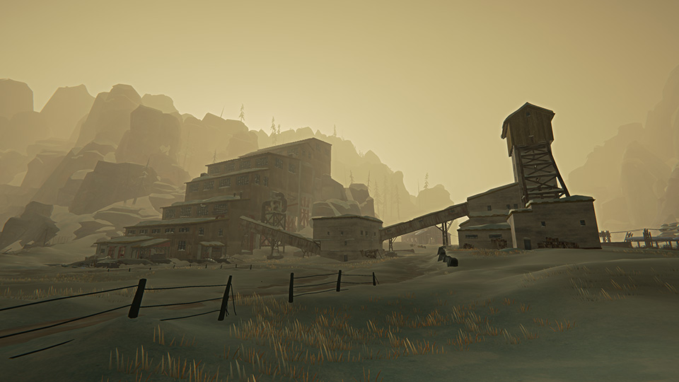 Foggy view of an old mining facility against a backdrop of towering cliffs.